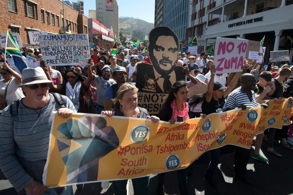 Protesters march with a cut-out poster of Atul Gupta through Cape Town in April 2017, calling on then South African President Jacob Zuma to step down. Photo: AFP