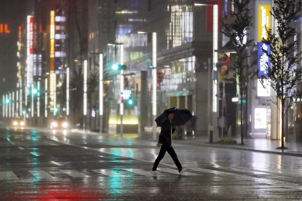 A man walks a pedestrian crossing at Ginza shopping district in the pouring rain because of Typhoon Hagibis in Tokyo on Saturday. Photo: AP