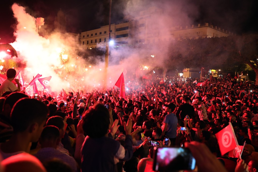 Supporters of Tunisian presidential candidate Kais Saied celebrate after unofficial results of the Tunisian presidential election in the capital Tunis. Photo: EPA-EFE