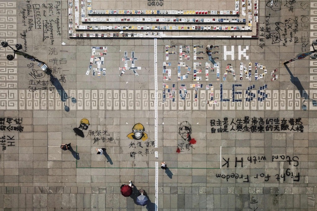 People walk past protest graffiti and posters on the grounds of Chinese University’s Sha Tin campus in Hong Kong on September 27. Photo: AFP