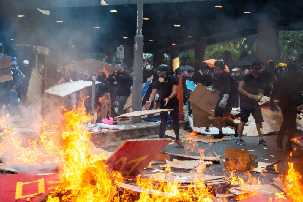 Demonstrators throw cardboard on a fire during a protest in the Central district of Hong Kong on Tuesday, October 1, 2019. Photo: Bloomberg