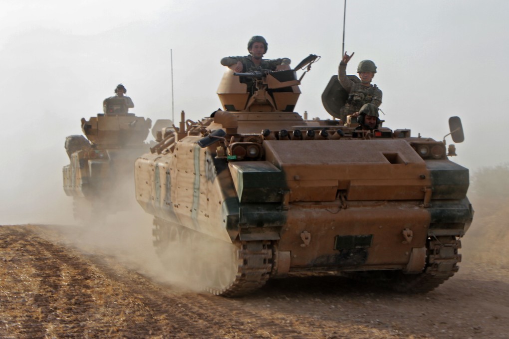 Turkish soldiers in armoured personnel carriers move through the town of Tukhar, north of Syria's northern city of Manbij. Photo: AFP