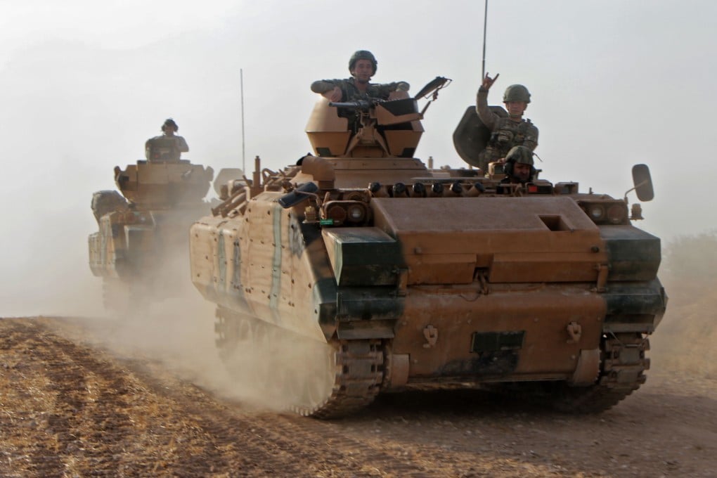 Turkish soldiers in armoured personnel carriers move through the town of Tukhar, north of Syria's northern city of Manbij. Photo: AFP