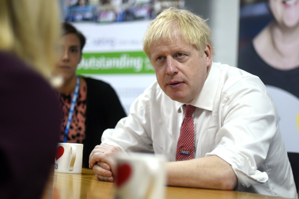 Britain's Prime Minister Boris Johnson speaks to mental health professionals during his visit to Watford General Hospital, in Watford, on October 7. Photo: AP