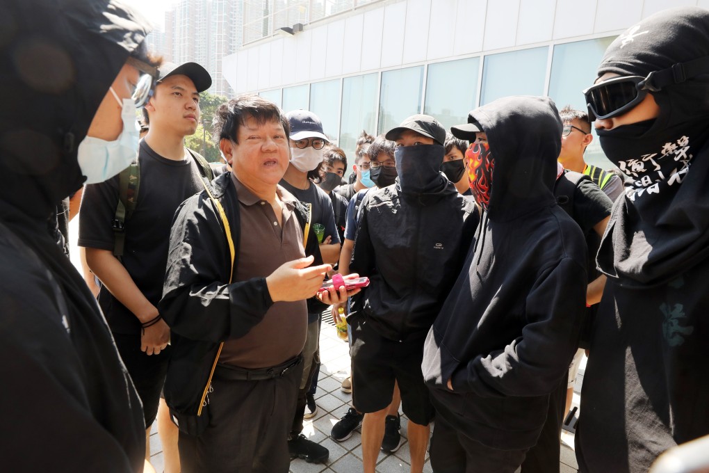A Hong Kong Design Institute employee is surrounded by students demanding the full CCTV footage. Photo: K.Y. Cheng
