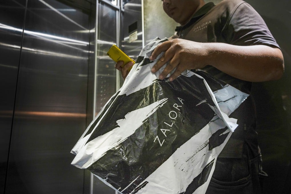 A Zalora courier makes a delivery in Kuala Lumpur. Couriers have to work fast lest a customer complains, and must put in long hours to pick up the bonuses that give them a living wage. Photo: Zahim Mohd