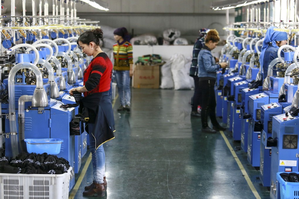 Staff members arrange cotton socks on a fully automatic hosiery machine at a knitting company in northwest China in 2017. Photo: Xinhua