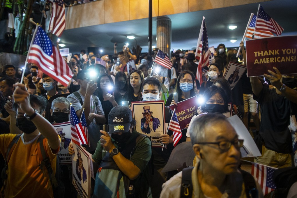 Demonstrators hold placards and American flags during a rally in support of the Hong Kong Human Rights and Democracy Act in Hong Kong on Monday. Photo: Bloomberg