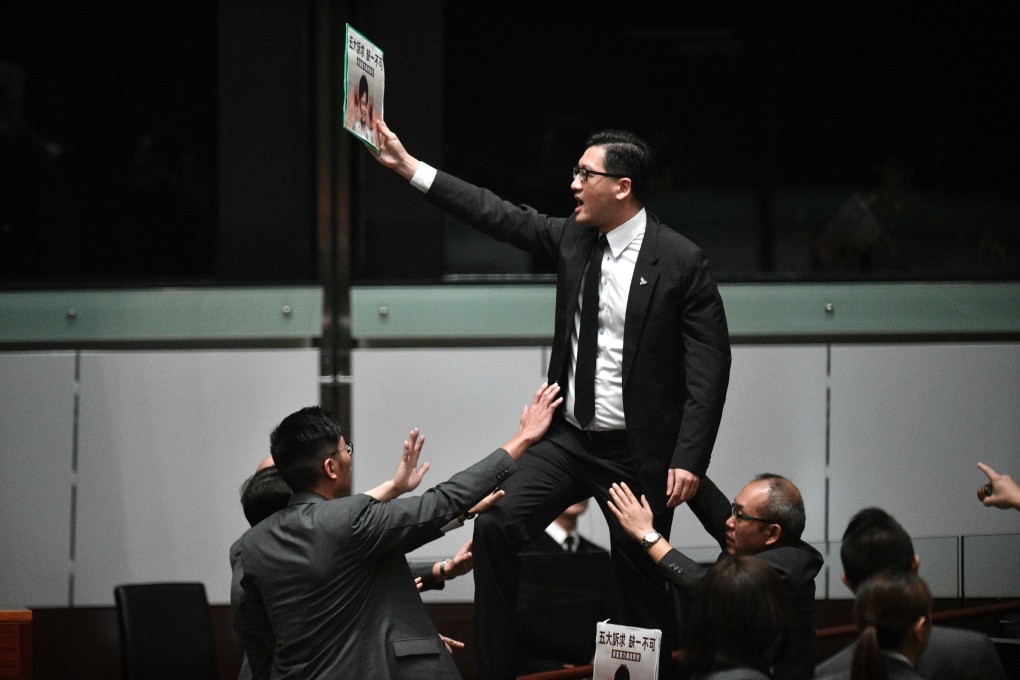 Pro-democracy lawmaker Lam Cheuk-ting stands up and protests after Chief Executive Carrie Lam retreated twice from the Legislative Council lectern on October 16. Carrie Lam later delivered her policy address by video. Photo: AFP