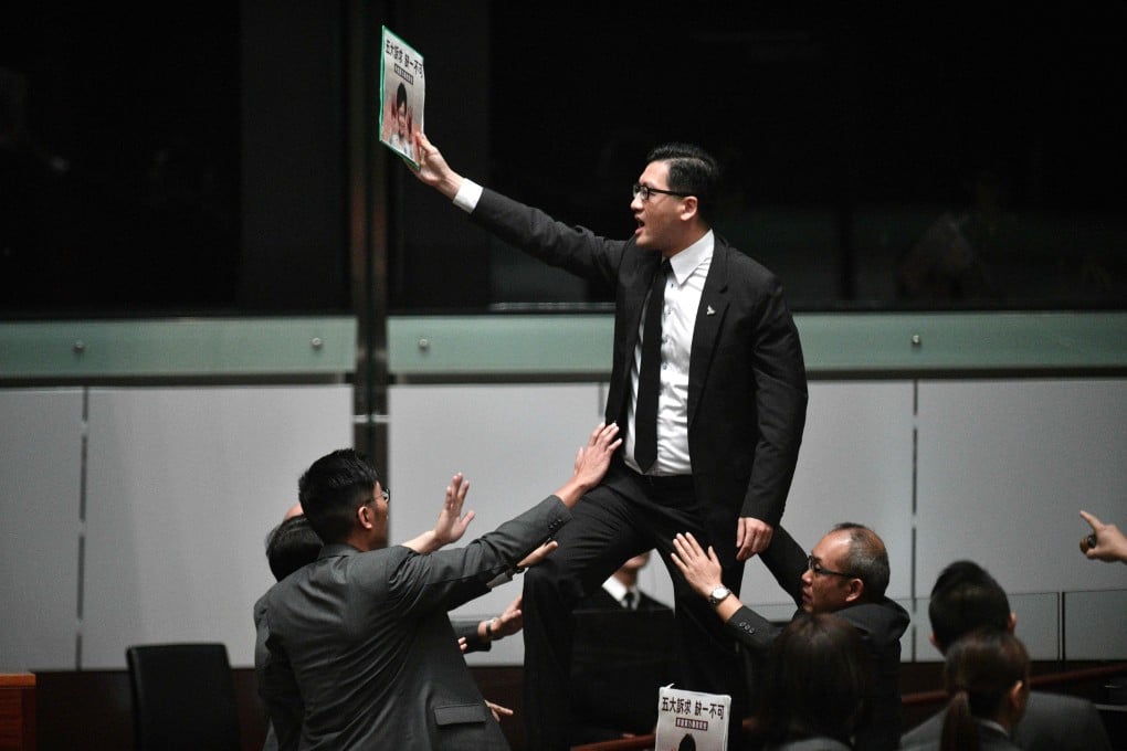 Pro-democracy lawmaker Lam Cheuk-ting stands up and protests after Chief Executive Carrie Lam retreated twice from the Legislative Council lectern on October 16. Carrie Lam later delivered her policy address by video. Photo: AFP