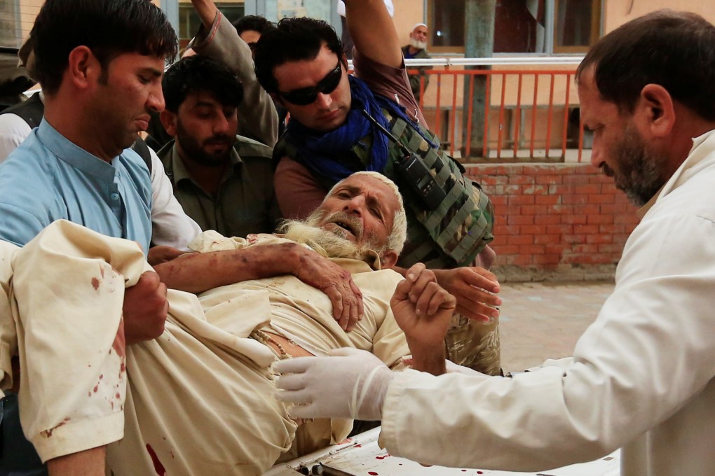Men carry an injured person to a hospital after a bomb blast at a mosque in Afghanistan. Photo: Reuters