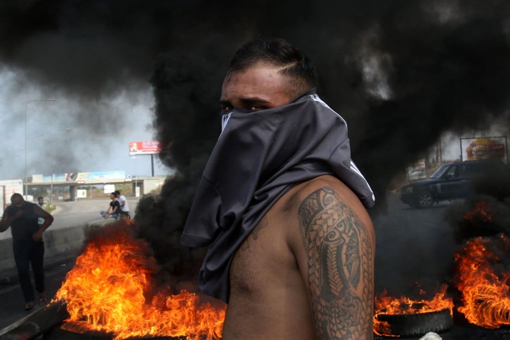 A Lebanese demonstrator stands in front of a tyre fire during a protest in southern Lebanon on Friday. Photo: AFP