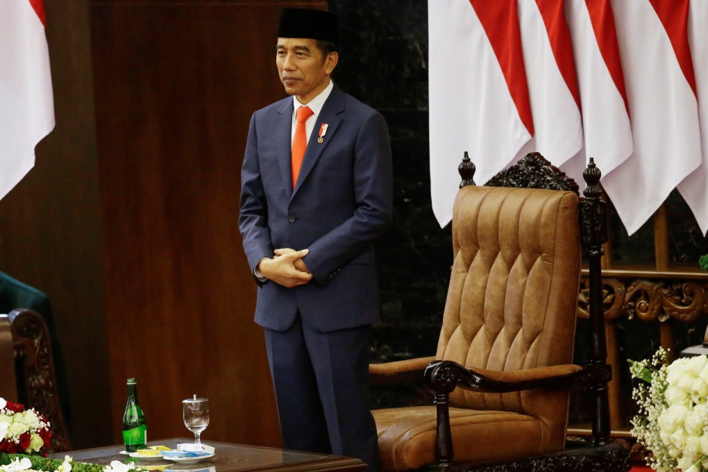 Indonesian President Joko Widodo stands after taking an oath during his inauguration for his second term, at the House of Representatives building in Jakarta. Photo: Reuters