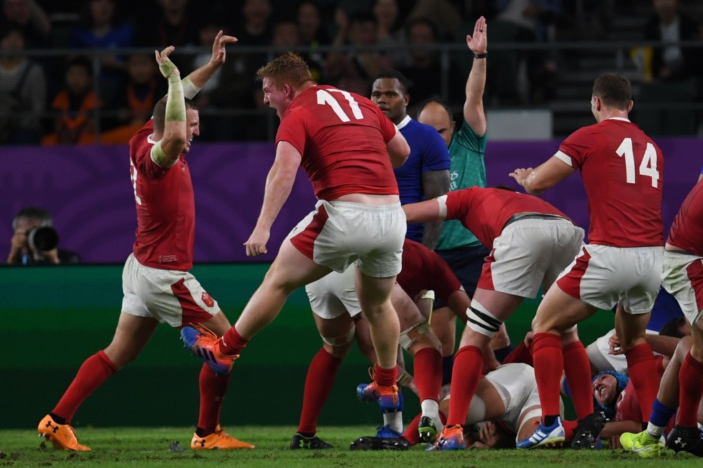 Wales players react after scoring a try against France. Photo: AFP