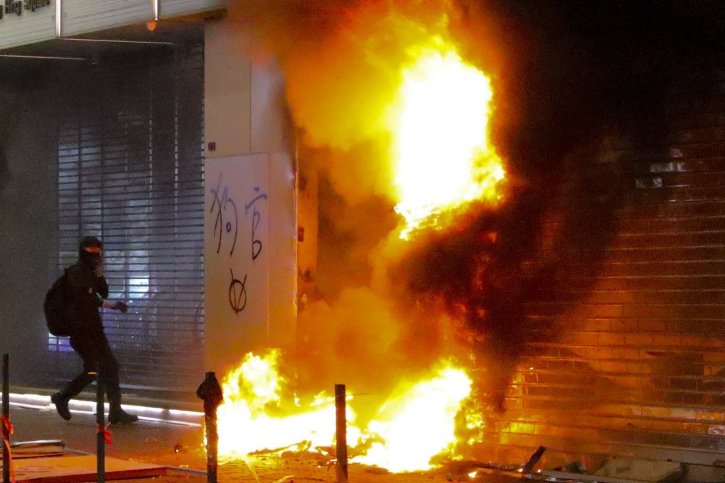 Masked anti-government protesters set stores on fire. Photo: May Tse