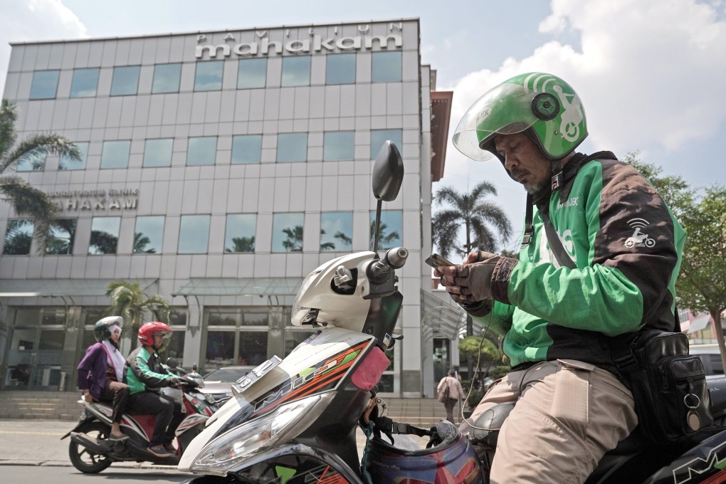 A Go-Jek motorcycle driver looks at a smartphone while preparing to deliver a prescription for a patient of Halodoc's online health-care platform outside an Apotik Mahakam pharmacy in Jakarta, Indonesia, on Thursday, July 11, 2019. Photo: Bloomberg