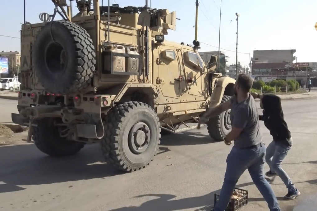 Residents angry over the US withdrawal from Syria hurl potatoes at American military vehicles in the town of Qamishli, northern Syria. Photo: AP