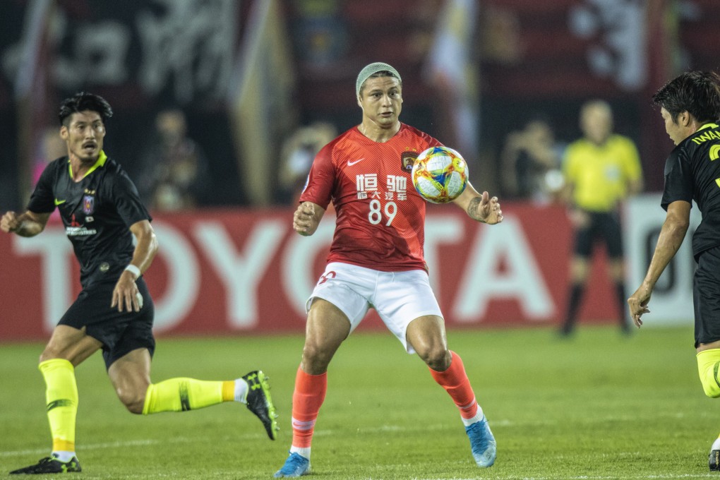 Ai Kesen Elkeson of Guangzhou Evergrande in action against Takuya Iwanami of Urawa Red Diamonds during their clash in Guangzhou. Photos: EPA