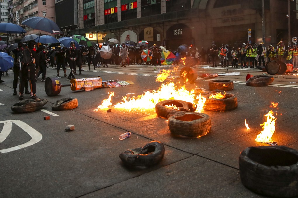 Anti-government protesters throw petrol bombs following a rally in defiance of the anti-mask law issued by the government, in Wan Chai on October 5. Photo: Winson Wong
