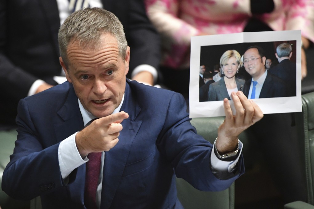 Opposition politician Bill Shorten holds up a photograph of Minister for Foreign Affairs Julie Bishop and Chinese businessman Huang Xiangmo in Parliament House in Canberra in June 2017. Photo: AAP via AP