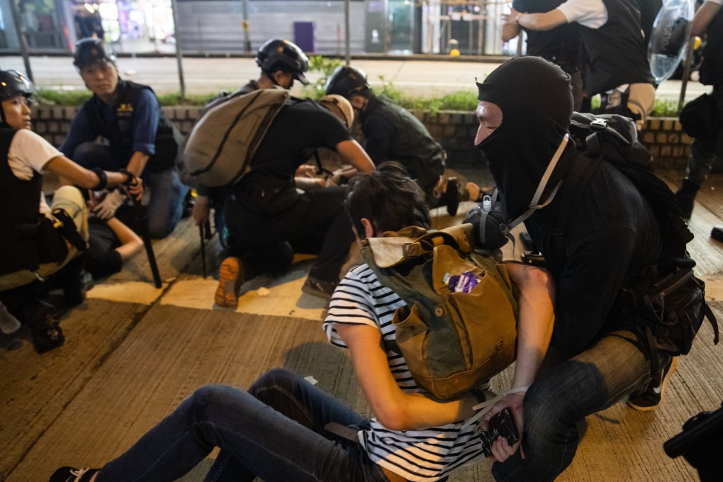 Men believed to be Hong Kong police officers dressed as protesters detain demonstrators on Hennessy Road during a protest in Causeway Bay on August 11. Photo: Bloomberg