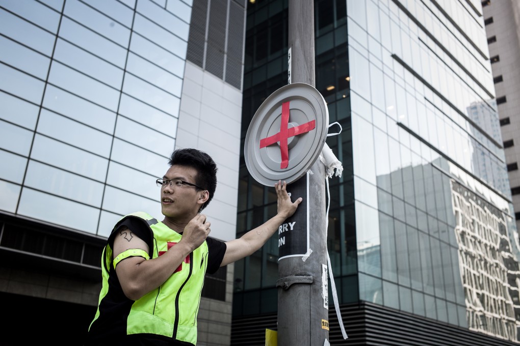 A pro-democracy demonstrator setting up a sign for a first aid zone near a barricade during the 2014 protests. Photo: AFP