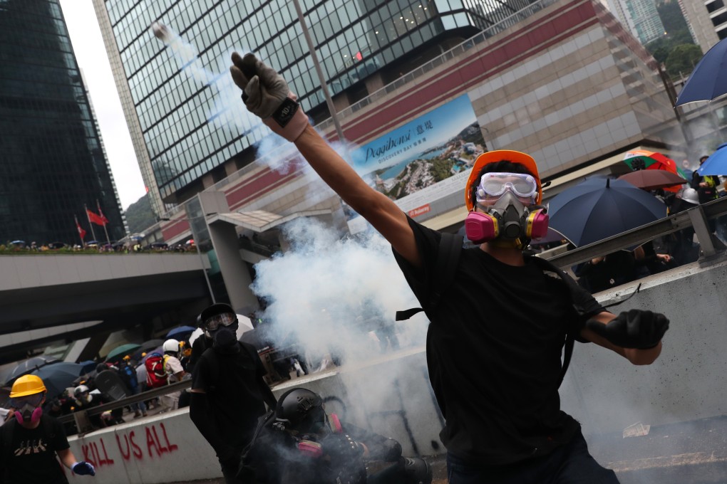 Anti-government protesters throw tear gas canisters back at police in Admiralty, central Hong Kong. Photo: Sam Tsang