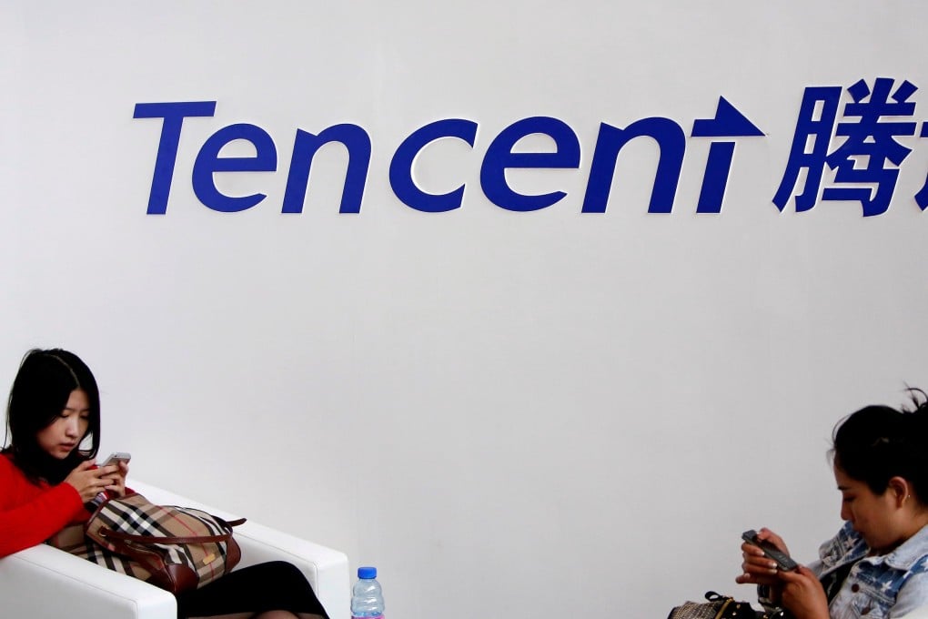 Tencent posted its biggest fall in two months on Wednesday, weighing down the Hang Seng Index. Above, women look at their smartphones underneath the Tencent logo. Photo: Reuters