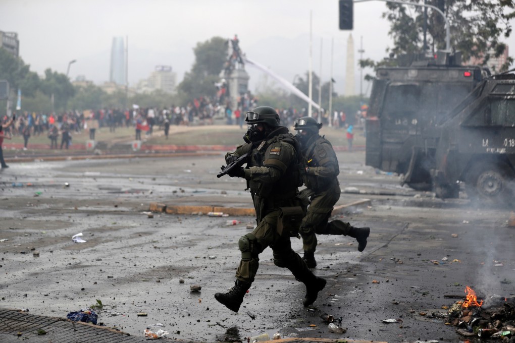 Riot police take up positions against demonstrators during a protest against Chile's state economic model in Santiago. Photo: Reuters