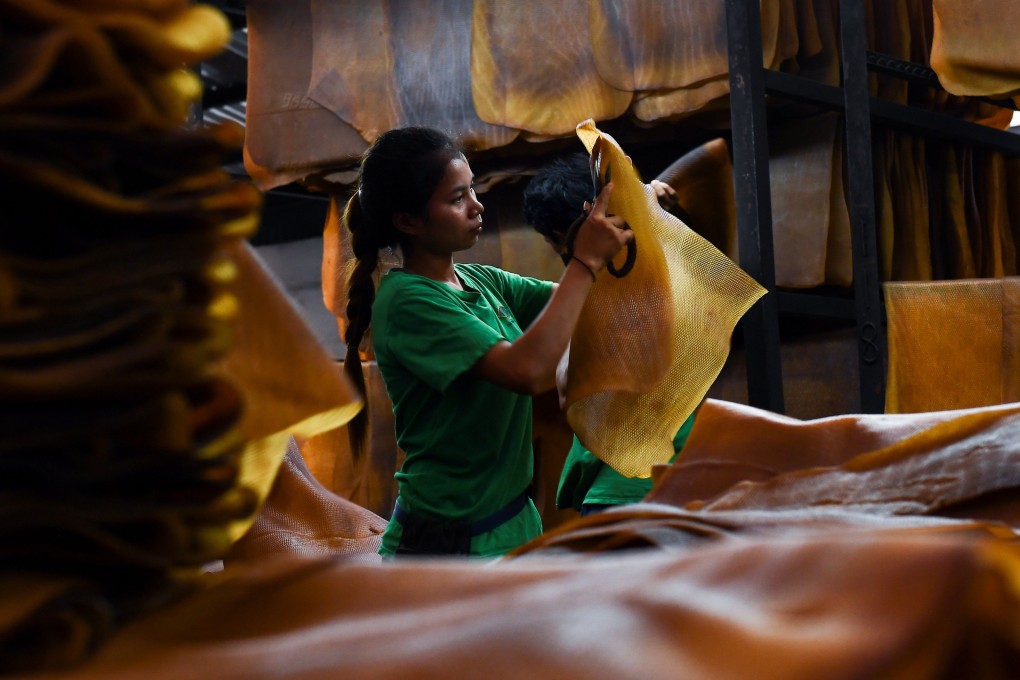A Thai worker cuts out stains from a raw rubber sheet at a factory in Rayong province. File photo: AFP