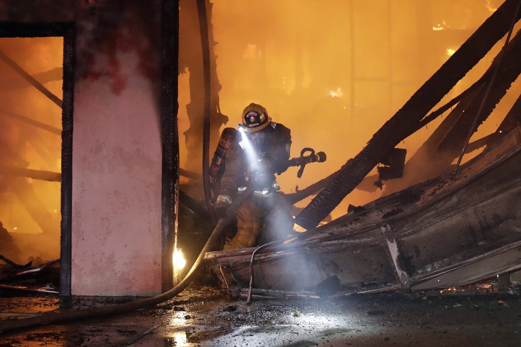 A firefighter at the scene of a fire-ravaged home in Santa Clarita, California. Photo: AP