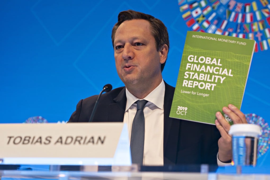Tobias Adrian, director of the monetary and capital markets department at the International Monetary Fund, holds up a copy of the Global Financial Stability Report at a news conference during the annual meetings of the IMF and World Bank Group in Washington, on October 16. Photo: Bloomberg
