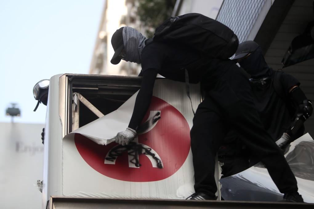 An anti-government protester vandalises the outside of Yau Ma Tei MTR station. Photo: Winson Wong