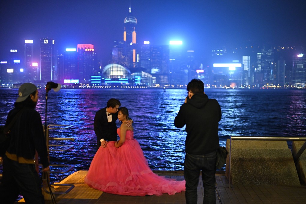 A newly wed couple pose for wedding photos with Hong Kong’s skyline acting as a backdrop. Photo: AFP