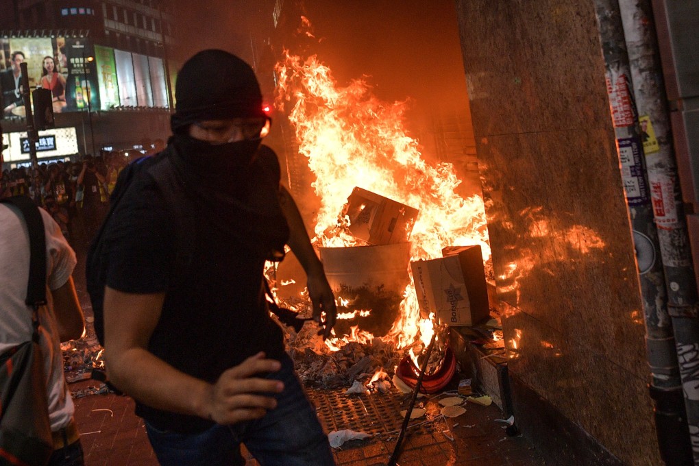 Hong Kong protesters burn items at a metro station entrance. Photo: AFP
