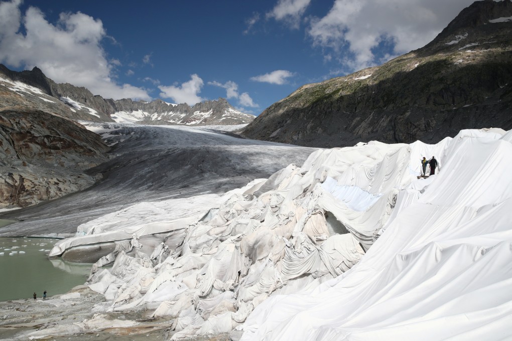 People enter the Ice Cave, covered with material to prevent the ice from melting, at the Rhone Glacier at the Furka, Switzerland. Photo: Reuters