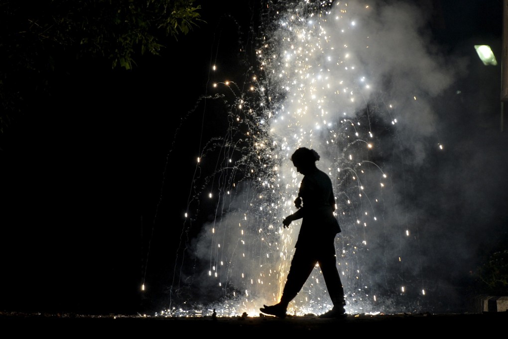 A woman is silhouetted by lit firecrackers during Diwali celebrations in Chennai. Photo: AFP