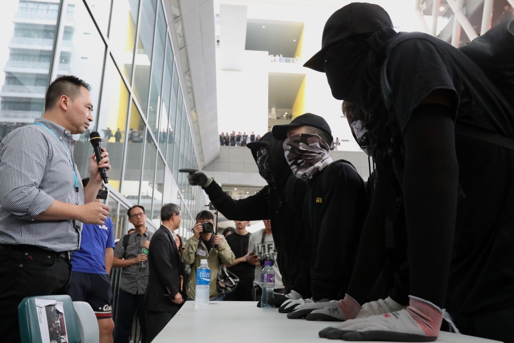 Masked protesters confront vice-principal Dr Joseph Wong during the dialogue on Tuesday. Photo: Felix Wong