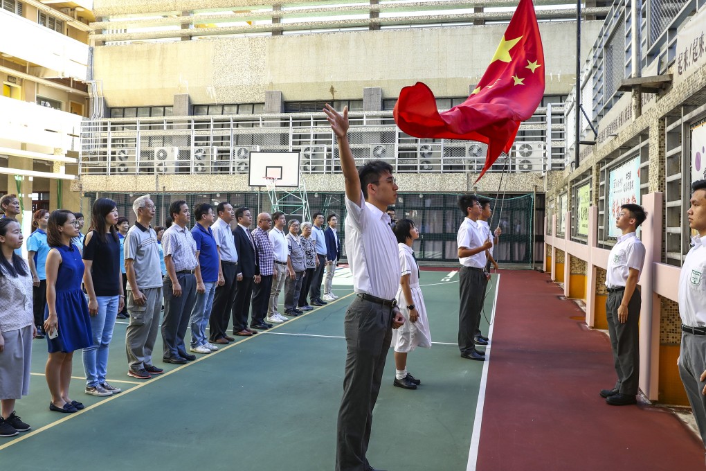 Students from Pui Kiu Middle School in North Point observing the national flag-raising ceremony in August. Photo: Nora Tam