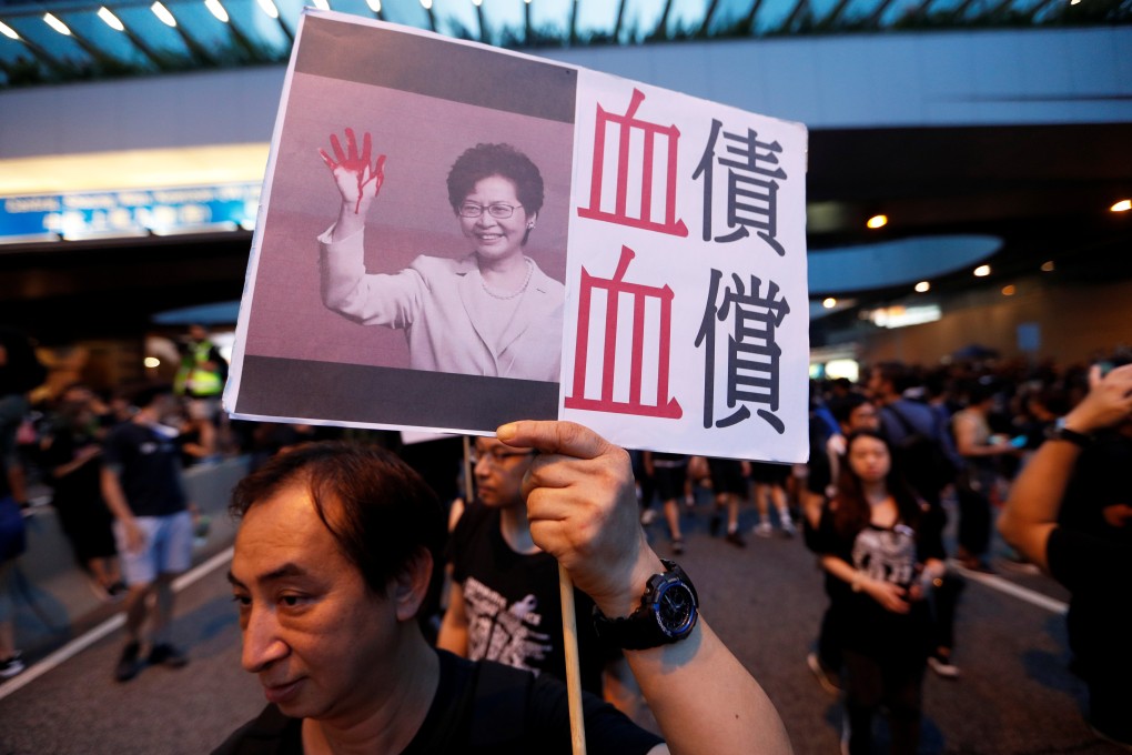 A protester holds a placard depicting Chief Executive Carrie Lam during a demonstration in Hong Kong on June 16. Photo: Reuters