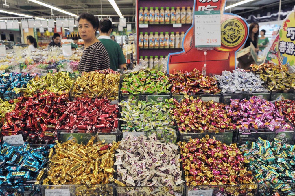 A woman walks by Hsu Fu Chi snacks in a supermarket in Shenyang in northeast China’s Liaoning province on July 5, 2011. Photo: EPA