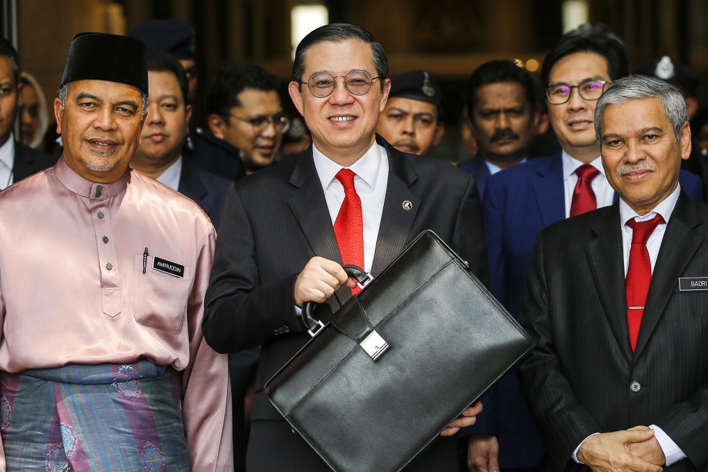 Malaysian Finance Minister Lim Guan Eng, centre, holds a briefcase containing budget documents outside the Finance Ministry earlier this month. Photo: EPA
