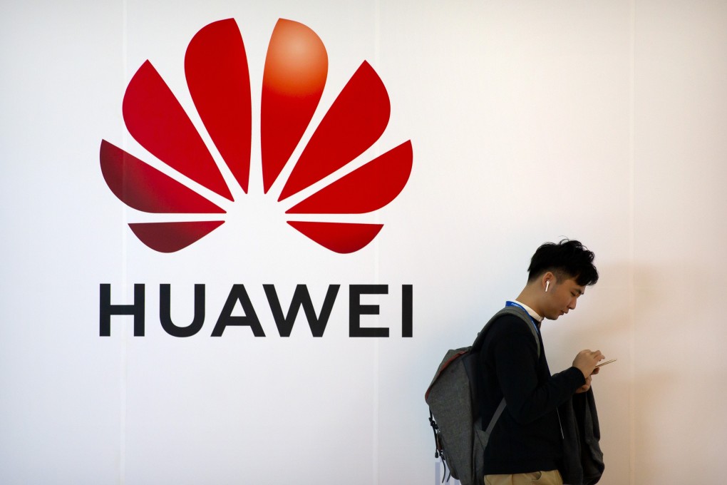 A smartphone user stands by Huawei Technologies signage at the PT Expo in Beijing on Thursday. In the war the US is waging on China tech firms, Huawei is the biggest target. Photo: AP
