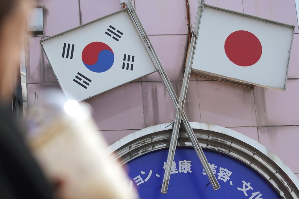 A woman walks past an advertisement featuring Japanese and South Korean flags at a shop in Shin Okubo area in Tokyo. Relations between Japan and South Korea are at their lowest point in years. Photo: AP