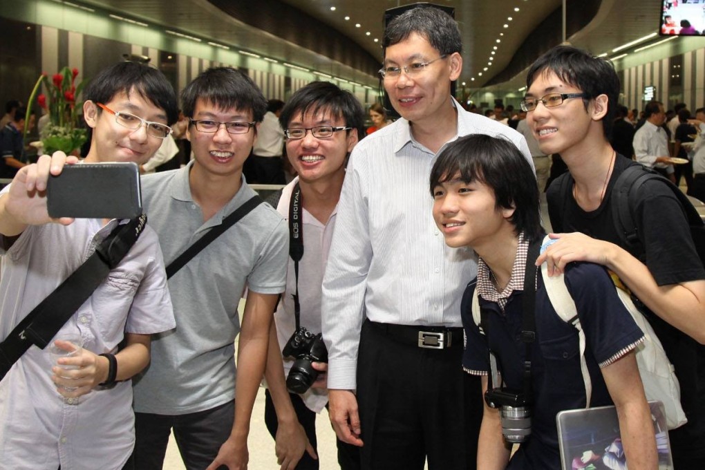Lui Tuck Yew (fourth from left) with Singapore MRT commuters. Photo: Facebook
