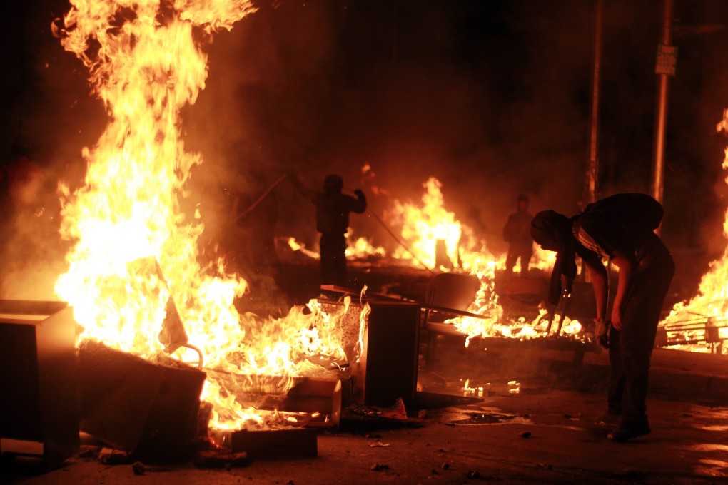 Groups of demonstrators clash with police during the 14th day of nationwide protests in Chile on Friday. Photo: EPA