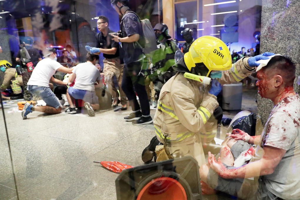 A firefighter attends to the suspected attacker while others help those injured in the incident. Photo: Edmond So