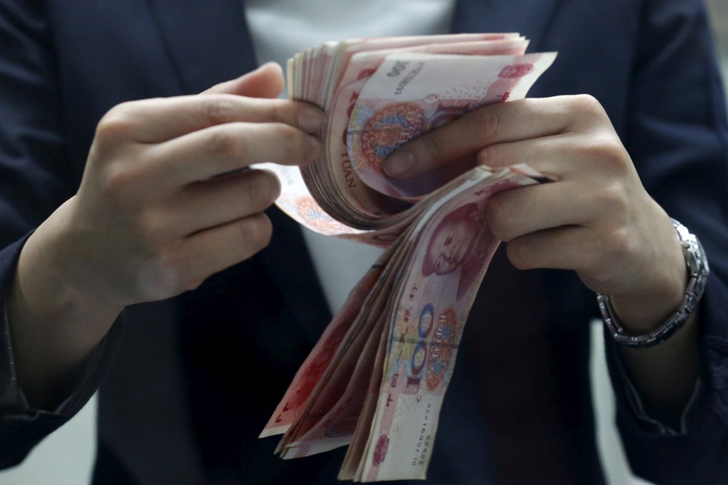 A clerk counting 100 yuan banknotes at a branch of a foreign bank in Beijing, on January 4, 2016. Photo: REUTERS