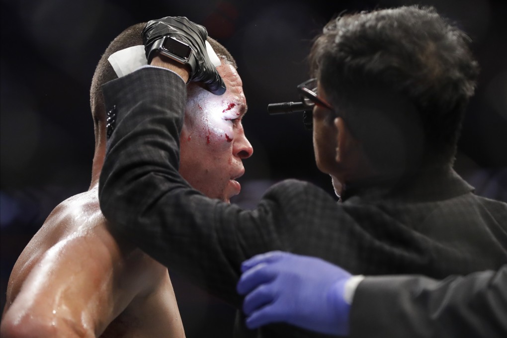 Dr Nitin K. Sethi checks Nate Diaz before the fourth round at UFC 244. Photo: AP