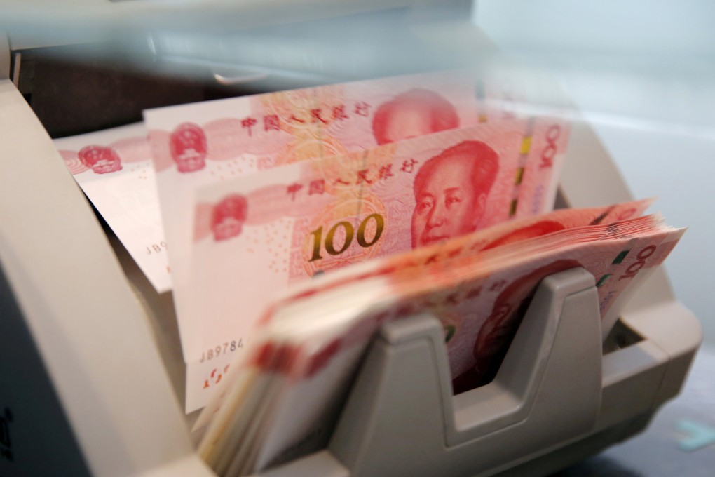 Chinese 100 yuan banknotes are seen in a counting machine while a clerk counts them at a branch of a commercial bank in Beijing, China. Photo: Reuters